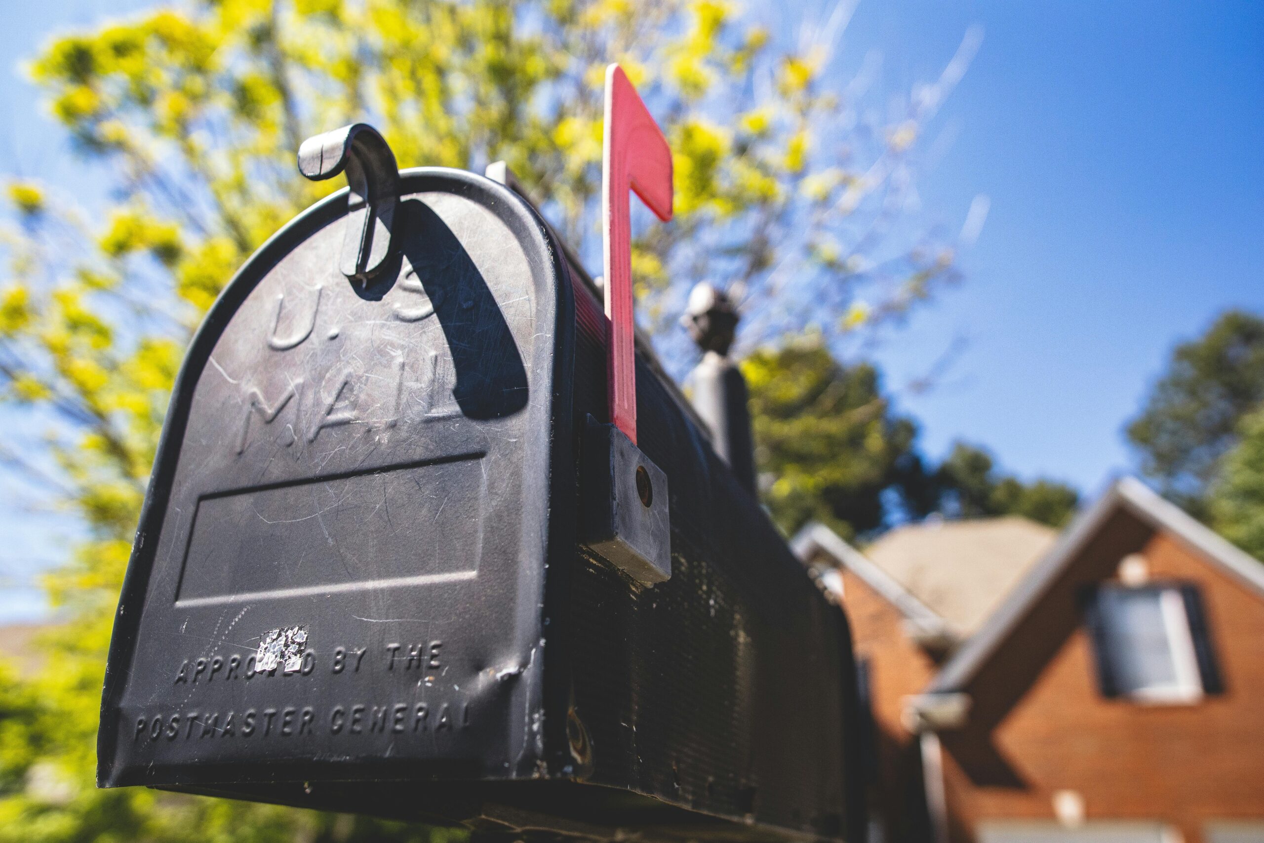 Close-up of a traditional US mailbox with a red flag in a sunny neighborhood. Best Personal Finance Blog for Investing & Retirement